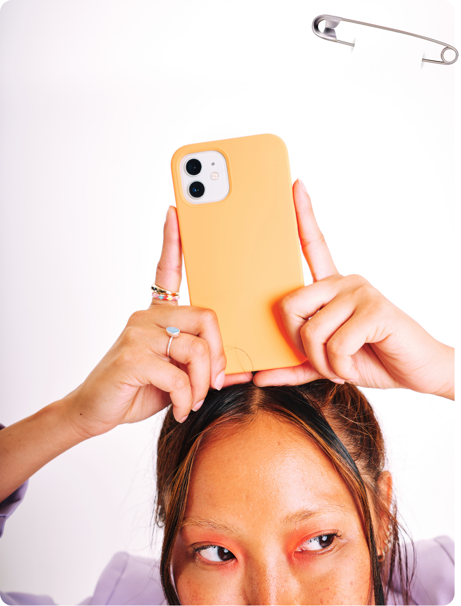 Persoon houdt oranje telefoon boven het hoofd